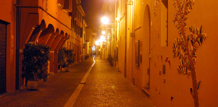Via Garibaldi di notte con l'albero delle ocarine sulla facciata del museo dell'Ocarina